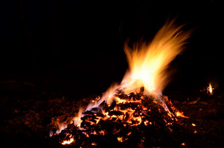 beautiful red hot glowing ember pile with colorful flames in winter night