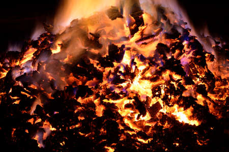beautiful red hot glowing ember pile with colorful flames in winter nightの写真素材