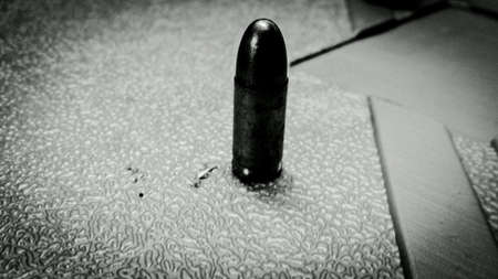 Dark pistol bullet senter frame macro photo