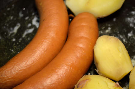 sausage and potato in frying pan with melted butterの写真素材