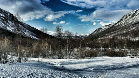 Wonderful mountain valley landscape in snowy winter wonderland with tromsoe city in the background