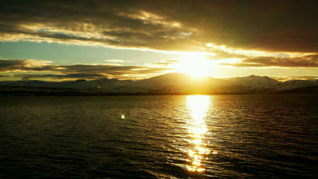 Golden sunset over fjord and mountainの素材