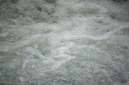 beautiful bubbly white foamy river water under waterfall