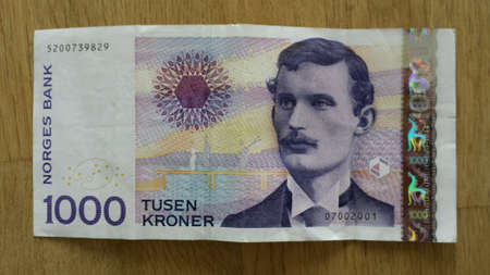 Norwegian one thousand crown paper money bank note currency closeup on wooden tableの素材