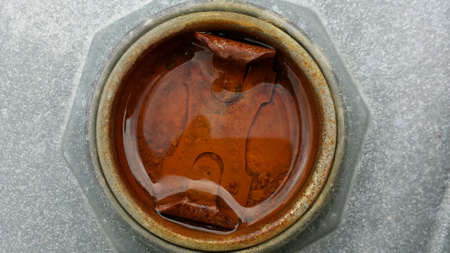 Old wet rust filled metal barrel cap closeup