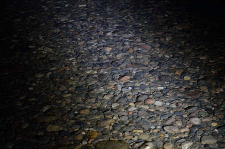 illuminated river rock at night under waterの写真素材