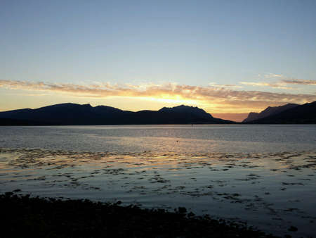 Golden sunset sky over mountain and fjord