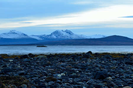 beautiful blue fjord with new snow on mountain backgroundの写真素材