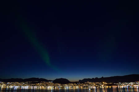 majestic aurora borealis dancing on night sky over the arctic circle city of tromsoe at dawnの写真素材