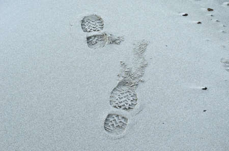 human shoe print on cold white frozen beach background