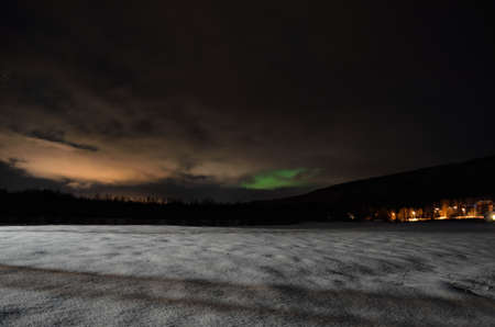 long white snowy field with green northern light in the backgroundの写真素材