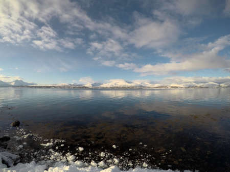 deeo blue ocean landscape with snowy mountain and sunshine