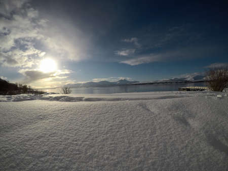 deeo blue ocean landscape with snowy mountain and sunshine