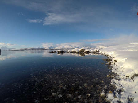 deeo blue ocean landscape with snowy mountain and sunshineの写真素材