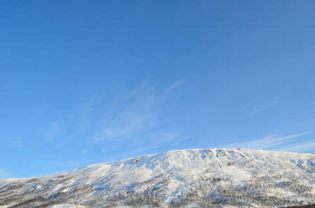 snowy mountain peak on blue sky background