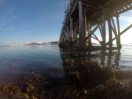 old car bridge over blue fjord as the winter sun is risingの写真素材