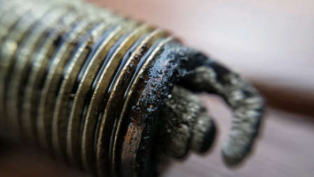 Old charred used car sparkplug macro photo