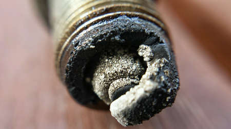 Old charred used car sparkplug macro photo