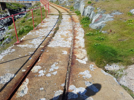 old concrete and metal trolley road with lighthouse backgroundの写真素材