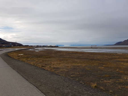 barren landscape with jagged mountain and blue water on svalbardの写真素材