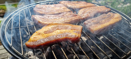 Grilled slices on pork on coal grill in summerの写真素材