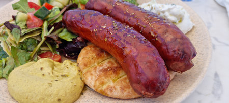 traditional greek dish with sausage, pure, vegetables and breadの写真素材