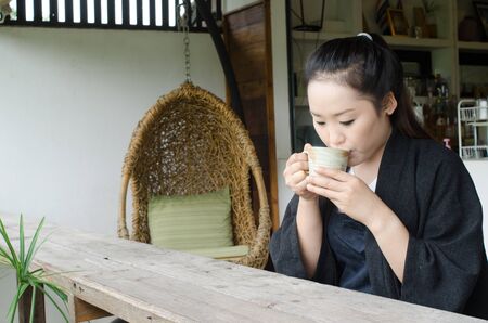 Women are drinking hot coffee in a coffee shop.の写真素材