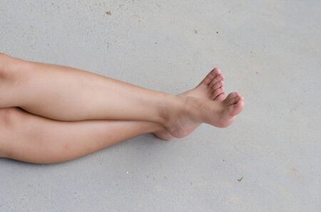 Beautiful sitting woman smooth on a concrete floorの写真素材