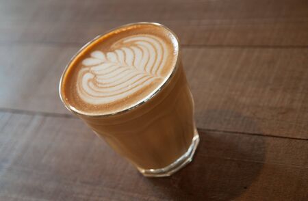 Hot coffee in a white cup on table. bubble Milk is not clear