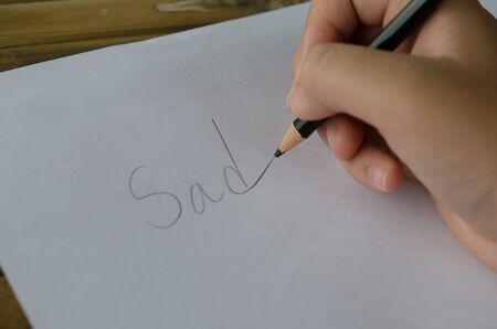 Closeup to man's hands using a Crayon on a paper sheetの写真素材