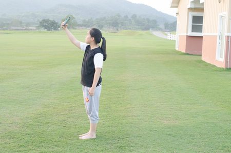 teenage girl in T-shirt playing her smart mobile phone .の写真素材