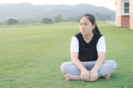 Young teenage girls sitting outside in a meadow  and on activities.の写真素材