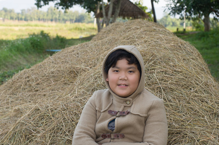 Smiling little boy in winter coat with natural backgroundの写真素材