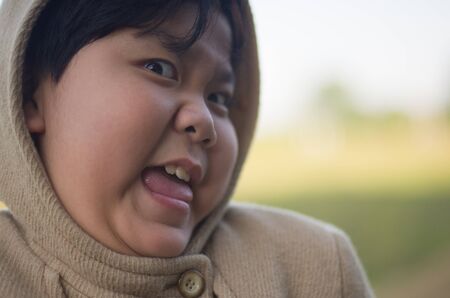 Smiling little boy in winter coat with natural backgroundの写真素材