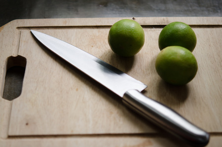 lime, lemon and knife on an old wooden in kitchen roomの写真素材