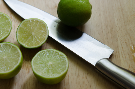 lime, lemon and knife on an old wooden in kitchen roomの写真素材