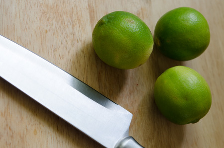 lime, lemon and knife on an old wooden in kitchen room