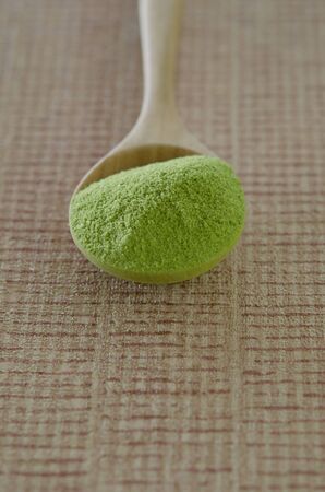 Wooden spoon with powdered matcha green teaの写真素材