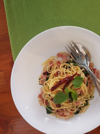 Spaghetti with dried chilli In dish on green colored tableclothの写真素材