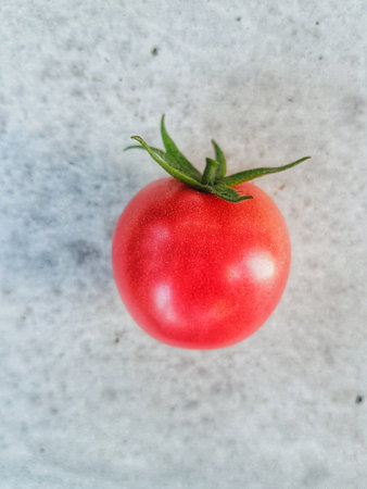 Ripe red cherry tomato on a gray background, top view.の写真素材