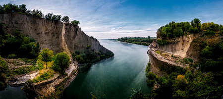 3D illustration. Beautiful cliff between the river and trees with dramatic blue sky design backgroundの写真素材