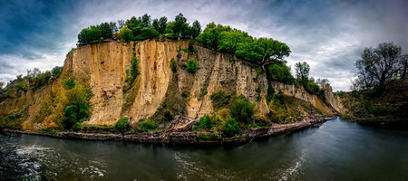 3D illustration. Beautiful cliff with river and trees with dramatic sky backgroundの素材