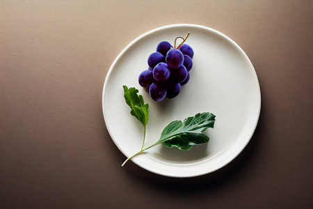 Grapes on the plate with pastel color table backgroundの素材