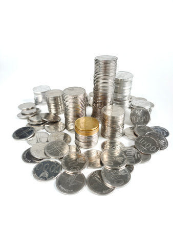 Pile of Indonesian's Rupiah coins isolated on white background. Some of them are stacked, some of them are scatteredの写真素材