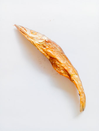 Fried salted fish isolated on white background. A side dish with a salty taste, but delicious to eat.の写真素材