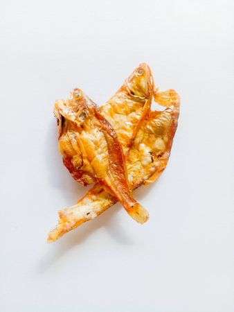 Fried salted fish isolated on white background. A side dish with a salty taste, but delicious to eat.の写真素材