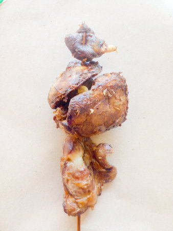 Delicious boiled chicken gizzard satay. Boiled chicken gizzard satay isolated on brown background.の写真素材