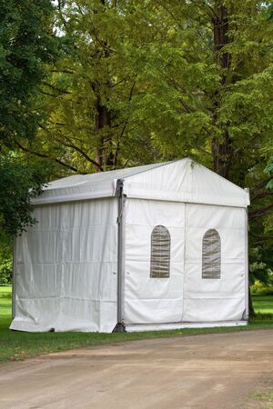 A white party or event tent on a meadow in a public parkの写真素材