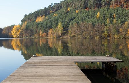 Lake with boat dock in the autumnの写真素材