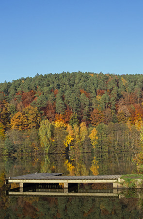 Lake with boat dock in the autumnの写真素材